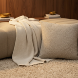 BRONS sierkussen Alentejo op een taupe bank met crème plaid