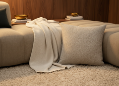BRONS sierkussen Alentejo op een taupe bank met crème plaid