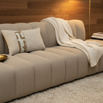 BRONS sierkussen Estoi oker stripe op een taupe bank met crème plaid