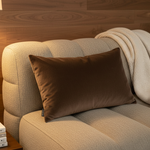 BRONS sierkussen Bilbao chocolat op een taupe bank met crème plaid
