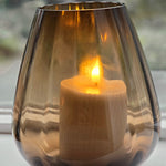 Tasman ribbed dark taupe van VTW met brandende kaars, de zachte ribbels in het rookglas van dichtbij