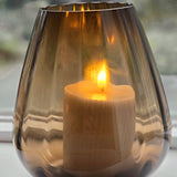 Tasman ribbed dark taupe van VTW met brandende kaars, de zachte ribbels in het rookglas van dichtbij